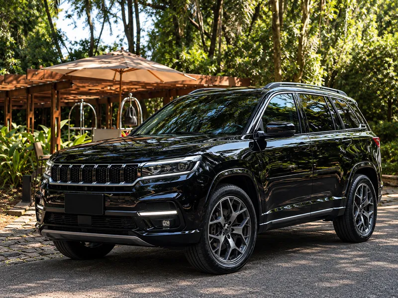 SUV blindado preto estacionado diante de um jardim arborizado