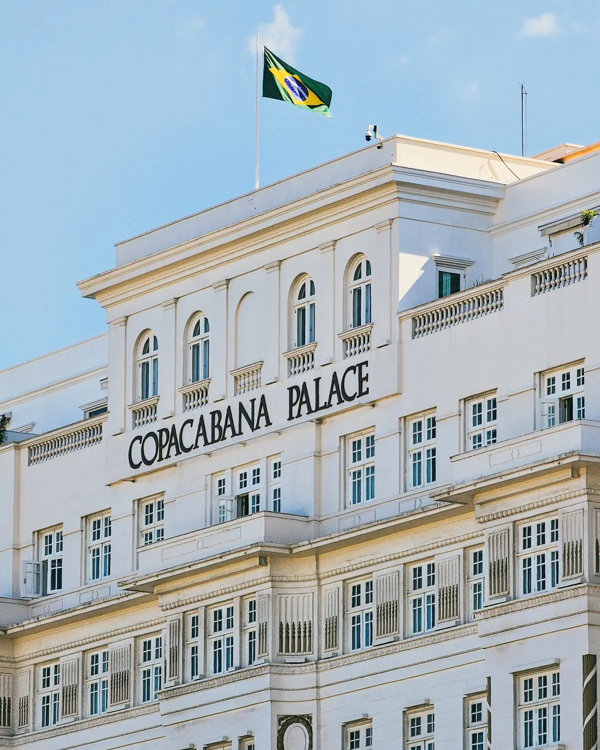 Fachada clássica do hotel Copacabana Palace, no Rio de Janeiro, com a bandeira do Brasil