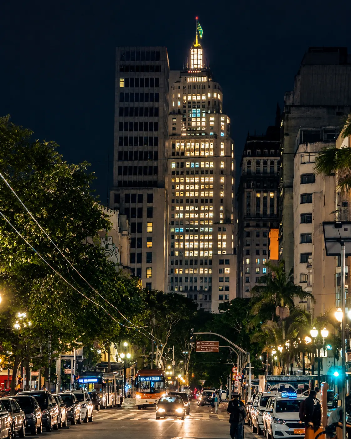 Avenida à noite rumo ao Farol Santander iluminado, no centro de São Paulo